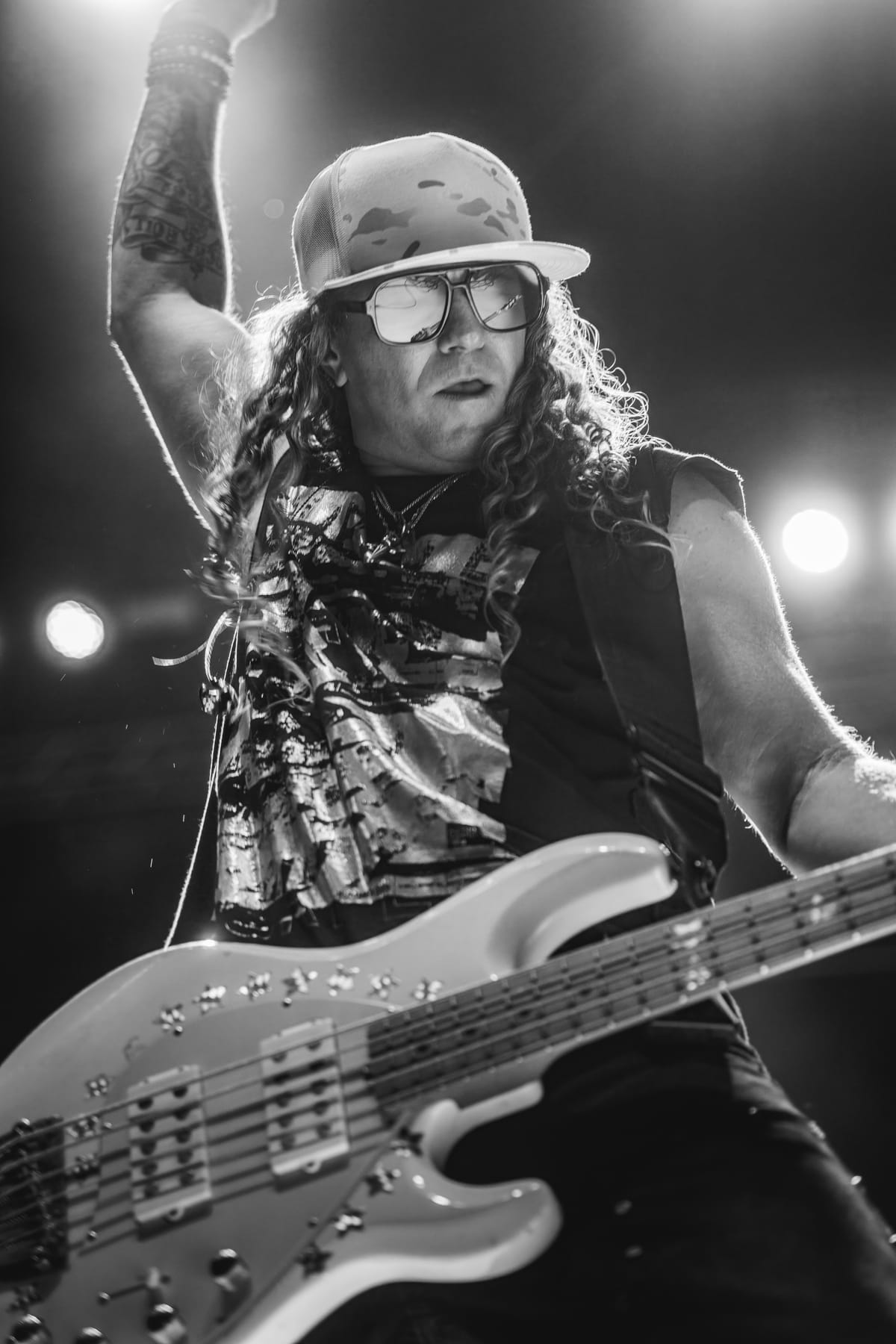 Guitarist mid-riff under a single spotlight, in black and white