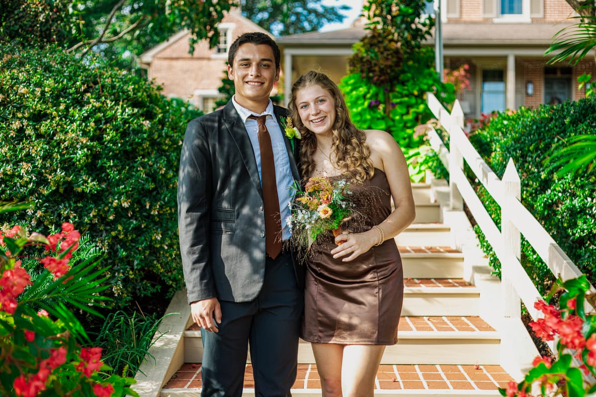 Formal portrait of a couple on a flower-lined staircase