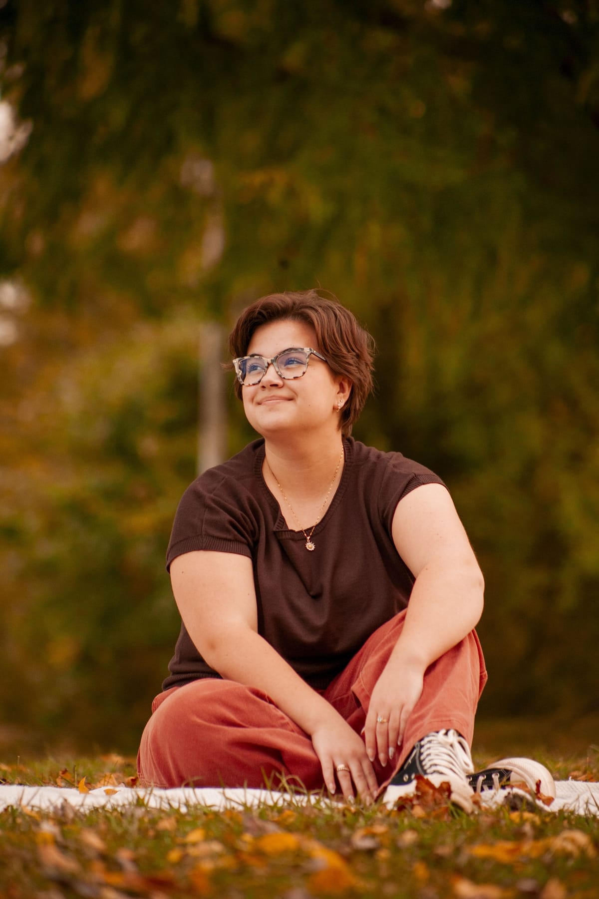 Portrait of a woman lit by warm evening light against greenery
