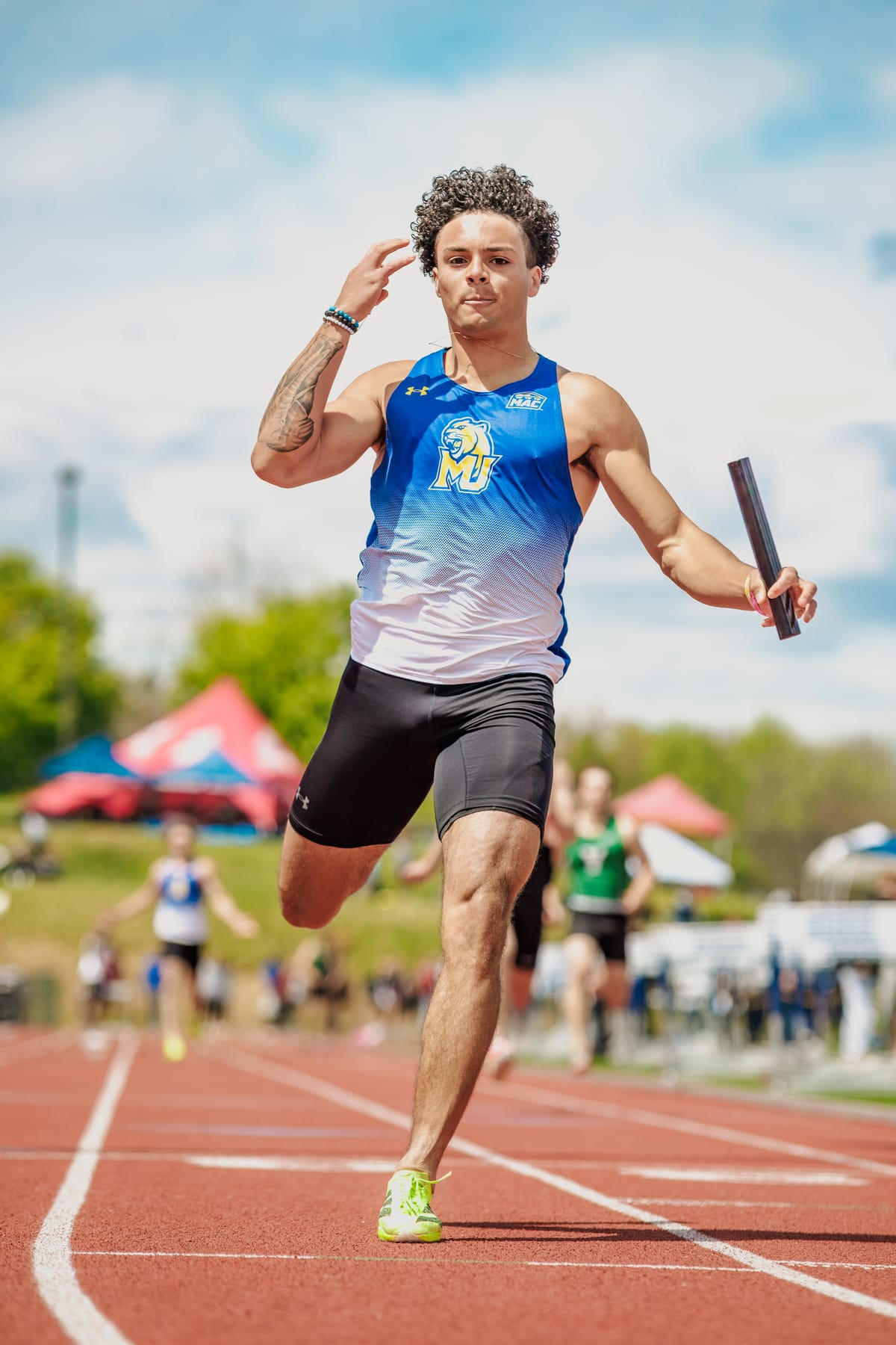 Runner sprinting with the relay baton in hand