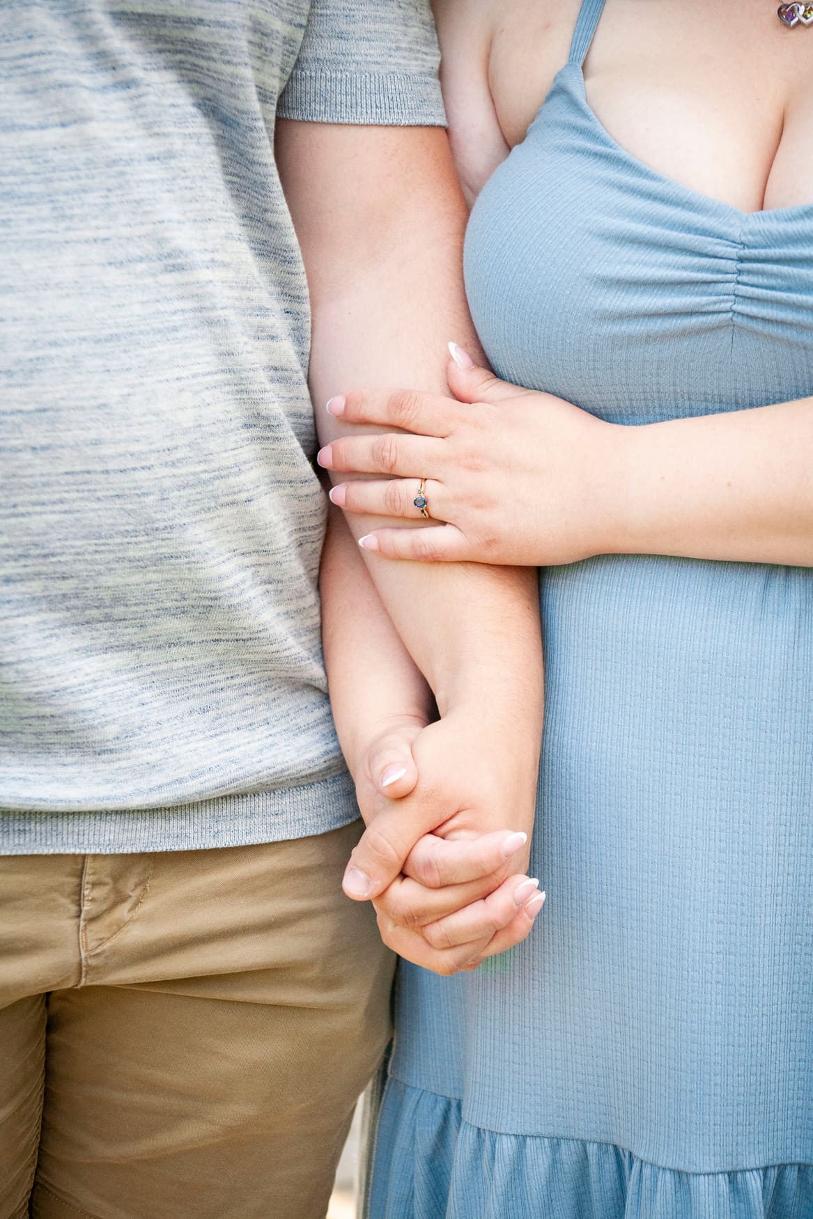 Close-up of the couple holding hands, engagement ring in focus